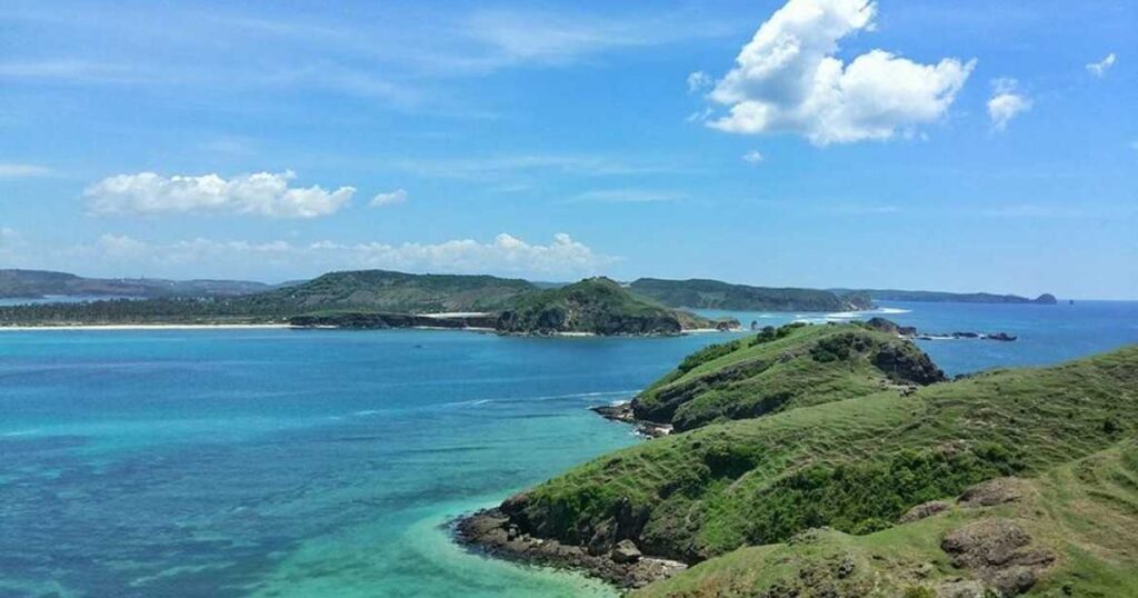 Panoramic view of Merese Hill Lombok with turquoise ocean, green hills, and beautiful coastline in South Lombok Indonesia